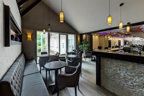 a restaurant with tables and chairs and a bar at Oázis Wellness Panzio in Szigetszentmiklós