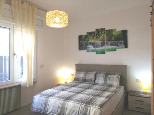 una camera con un letto, due lampade e una finestra di Appartamenti Scilla e Lavinia a Riva del Garda