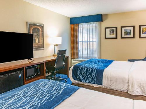 a hotel room with a bed and a desk with a tv at Comfort Inn in Piketon