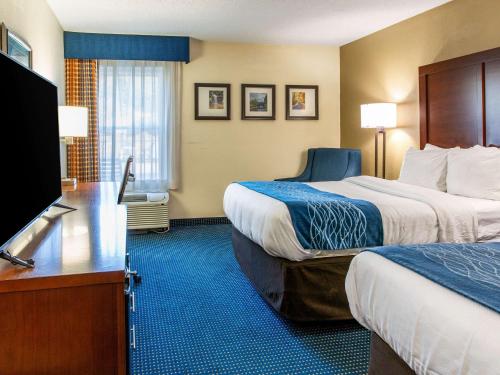 a hotel room with two beds and a flat screen tv at Comfort Inn in Piketon