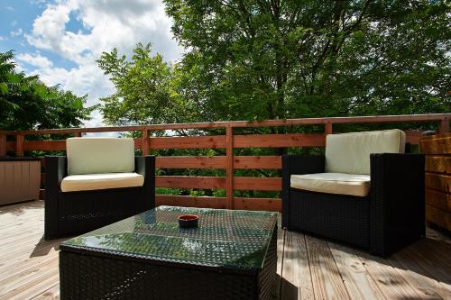 two chairs and a table on a wooden deck at Logis Hôtels Troglododo in Azay-le-Rideau