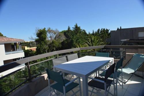 une table bleue et des chaises sur un balcon dans l'établissement Bel Appartement 2 pièces 200m Plages, à Cavalaire-sur-Mer