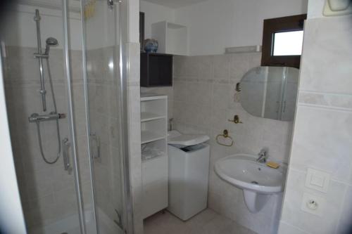 une salle de bain blanche avec une douche et un lavabo dans l'établissement Bel Appartement 2 pièces 200m Plages, à Cavalaire-sur-Mer