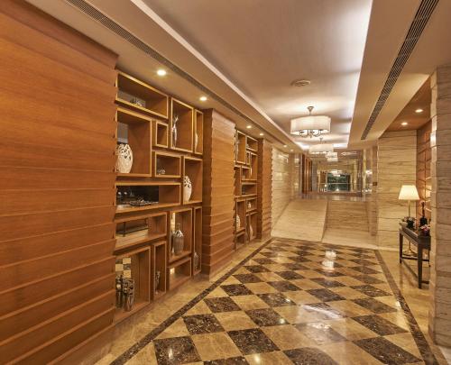a hallway with wood paneling and a checkered floor at Royal Orchid Central Grazia, Navi Mumbai in Navi Mumbai
