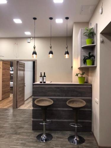 una cucina con due sgabelli e un bar con luci di Street51 a Yerevan