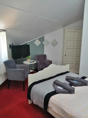 a hotel room with two beds and a chair at Bizant Boutique in Bacău