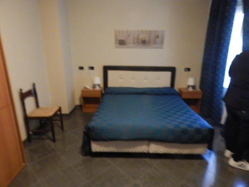 a bedroom with a blue bed and a chair at albergo massimo in Loano