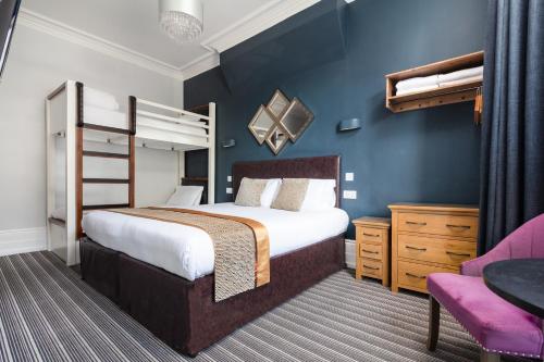 a bedroom with a bed and a bunk bed at Applewood Hotel in Bournemouth