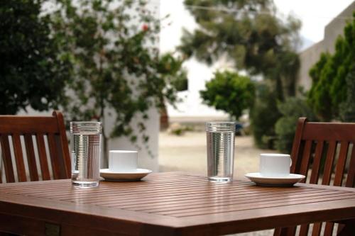 un tavolo di legno con tazze e piattini sopra di Katerina & Joanna Adamas Studio Milos ad Adámas