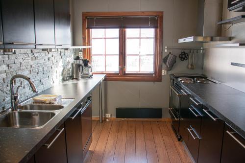 a kitchen with a sink and a wooden floor at Høvringen Fjellstue in Høvringen
