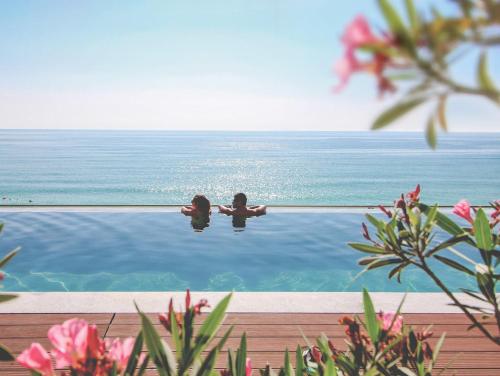 two children are sitting in the water in a swimming pool at MediSPA Grifid Encanto Beach Hotel - Ultra All Inclusive & Private Beach in Golden Sands