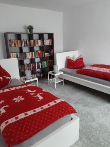 a bedroom with two beds and a book shelf at Haus Sorgenfrei in Caputh