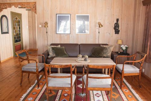 a living room with a couch and a table and chairs at Høvringen Fjellstue in Høvringen