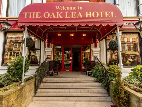 a hotel entrance with a red awning and stairs at Oak Lea Hotel in Blackpool