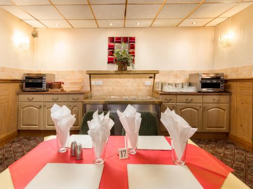 a kitchen with a table with a red table cloth at Oak Lea Hotel in Blackpool