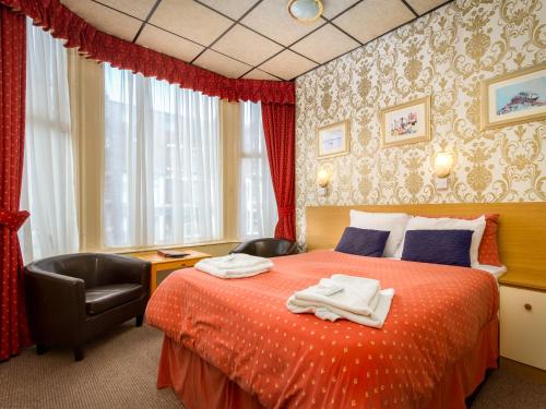 a bedroom with a bed with two towels on it at Oak Lea Hotel in Blackpool