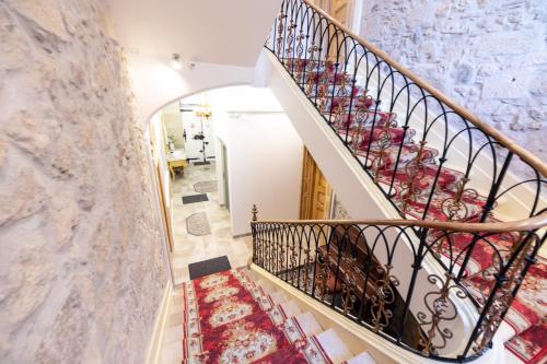 a staircase in a home with a marble wall at Suite Impériale Église du Couvent in Narbonne