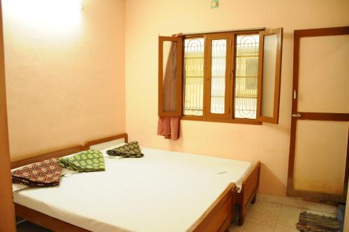 ティルヴァンナーマライにあるArunachala Ramana Homeのベッドが2つと窓のある部屋