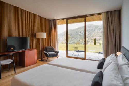 um quarto de hotel com uma cama e uma grande janela em La Galiana Golf Resort - Adults Only em Barraca de Aguas Vivas