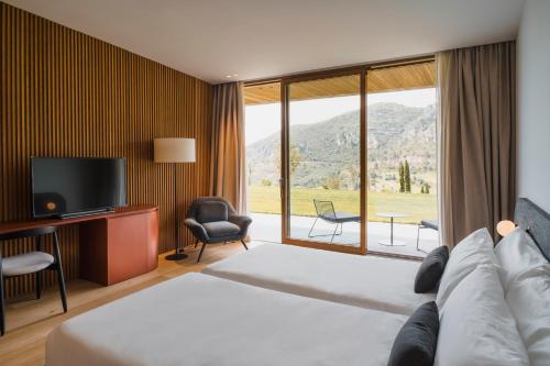 a hotel room with a bed and a large window at La Galiana Golf Resort - Adults Only in Barraca de Aguas Vivas