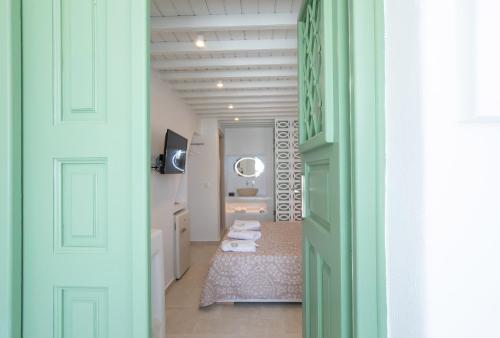 um corredor com um quarto com uma cama e um espelho em Mylos Suites em Míconos