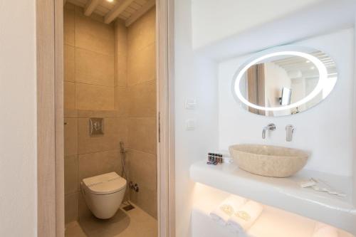 a bathroom with a sink and a toilet and a mirror at Mylos Suites in Mýkonos City
