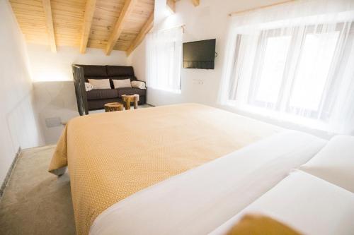 a bedroom with a large bed and a chair at El Pequeño Pajar in Majaelrayo