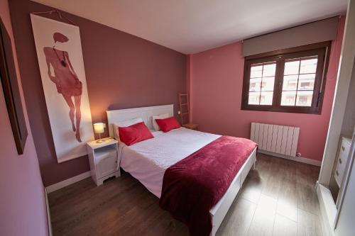 a bedroom with a bed with red pillows and a window at Apartamento Las Rozas Village in Las Rozas de Madrid