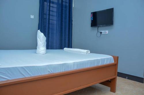 a bedroom with a bed with a television on the wall at Johnsons StopPoint in Zame