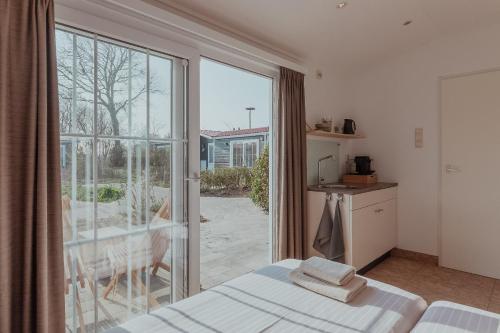 a bedroom with a bed and a large window at Ons Buiten in Oostkapelle