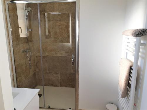 een douche met een glazen deur in de badkamer bij Les Bastidons de l'Isle - Le Seguret - 3 étoiles in LʼIsle-sur-la-Sorgue