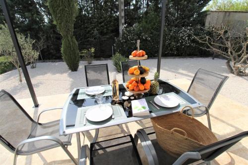 une table avec un bol de citrouilles dessus dans l'établissement Les Bastidons de l'Isle - Le Seguret - 3 étoiles, à LʼIsle-sur-la-Sorgue