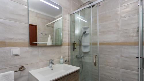 y baño con lavabo y ducha acristalada. en Comfort 1BDR Apartment W/Pool by LovelyStay, en Portimão