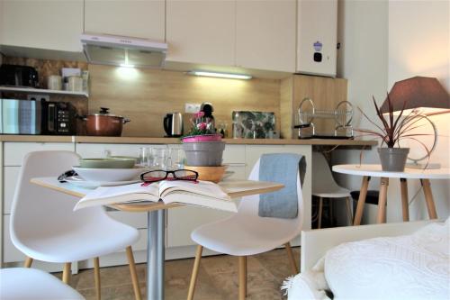 a table with a book and glasses on it in a kitchen at Les Bastidons de l'Isle - Le Saumane - 3 étoiles in LʼIsle-sur-la-Sorgue