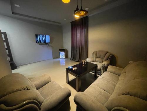 a living room with two couches and a tv at Lux Plaza Hotel in Arbatʼ
