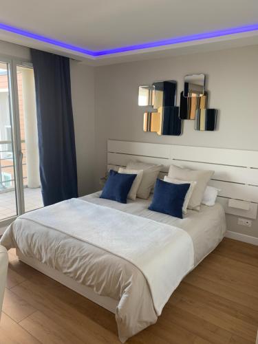 um quarto com uma cama grande e almofadas azuis em Horizon Bleu em Deauville