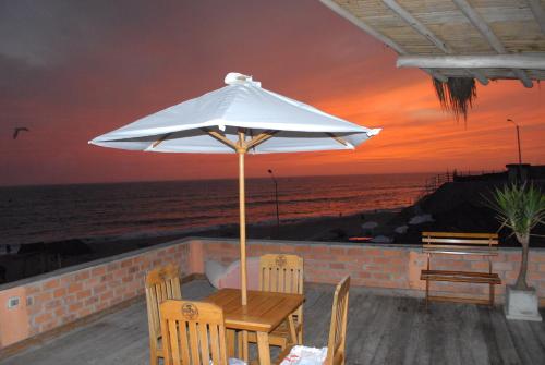 a table and chairs under an umbrella on the beach at Hamacas in Punta Negra