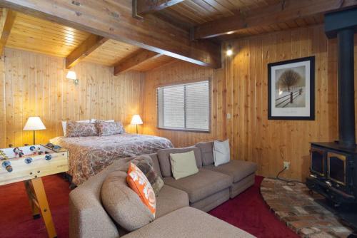 a bedroom with a bed and a couch in a room at Switzerland Ski Chalet-845 by Big Bear Vacations in Big Bear Lake