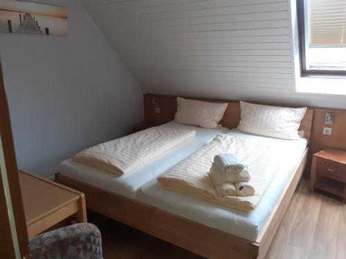 a bed in a room with two teddy bears on it at Weinhaus Hotel in Norddeich