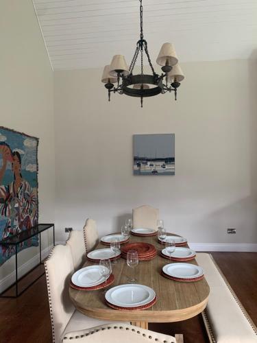a dining room with a table with chairs and a chandelier at Mount Juliet luxury residence in Ballylinch Bridge