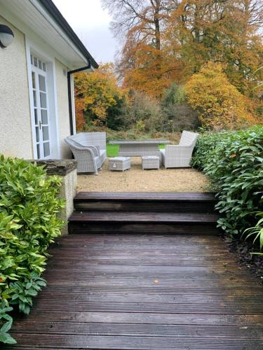 a wooden walkway with two chairs and a table at Mount Juliet luxury residence in Ballylinch Bridge