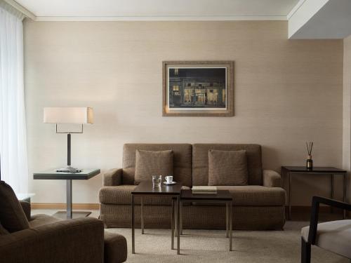a living room with a couch and a table at Galaxy Iraklio Hotel in Heraklio Town