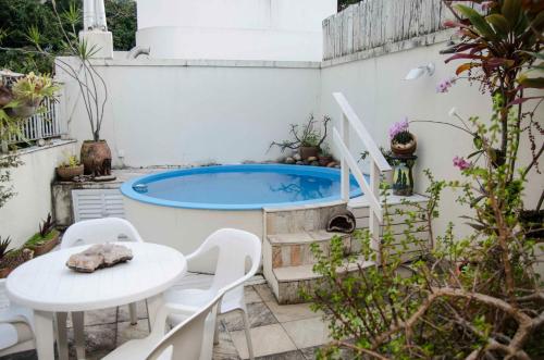 a patio with a table and a swimming pool at Alto Leblon in Rio de Janeiro