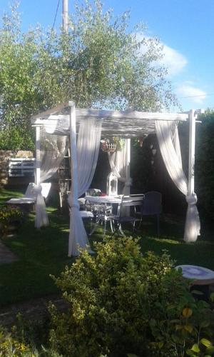 a white gazebo with a table and chairs under it at Casolare Isabella "Il rifugio dei vinili" and Alice's room in Ponsacco