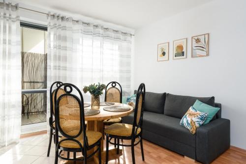 a living room with a couch and a table and chairs at Sleepway Apartments -Boho Chic in Poznań
