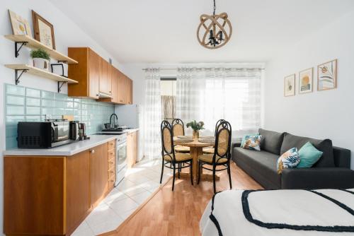 a kitchen and living room with a couch and a table at Sleepway Apartments -Boho Chic in Poznań