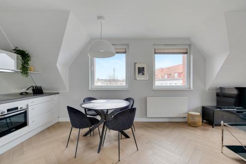 Una cocina y un comedor con mesa y sillas. en Tartaczna Apartments City Center & Parking by Downtown Apartments, en Gdansk