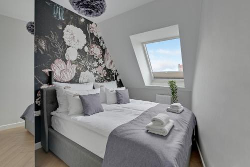 a bedroom with a bed with two towels on it at Downtown Apartments City Center Tartaczna Apartments & Parking in Gdańsk