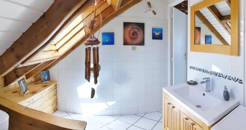 ein Badezimmer mit einem weißen Waschbecken und einer Holzdecke in der Unterkunft Chez Claire & Eric in Terre-de-Haut