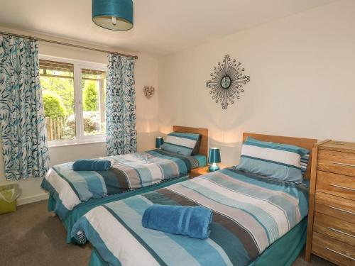 1 dormitorio con 2 camas y ventana en Hillside, en Callington
